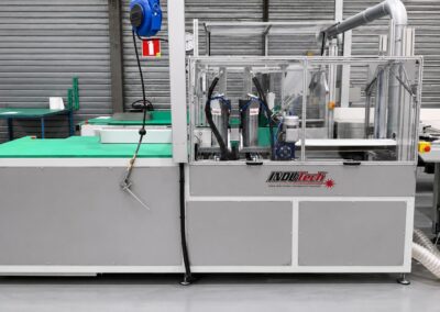 Vue latérale de la machine automatique de découpe des quatre coins de paquets en carton